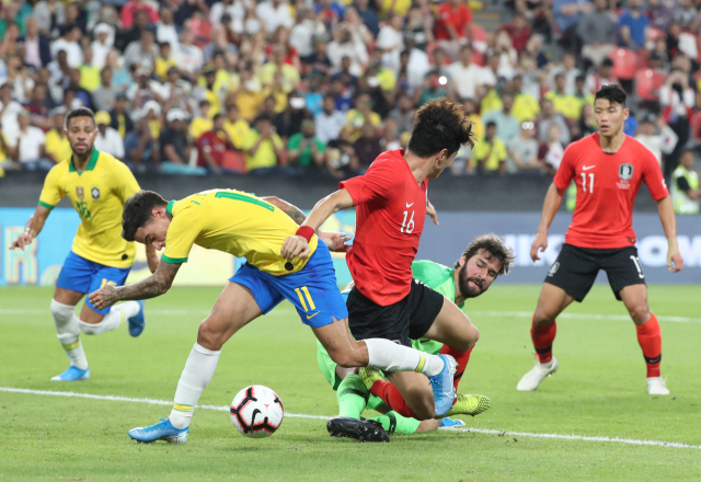 19일 아랍에미리트(UAE) 아부다비 모하메드 빈 자예드 스타디움에서 열린 한국과 브라질 축구 대표팀 평가전에서 한국 황의조가 브라질 쿠티뉴와 골키퍼 알리송을 피해 슈팅을 시도하고 있다. 이날 경기서 한국은 3대 0으로 완패했다. 연합뉴스
