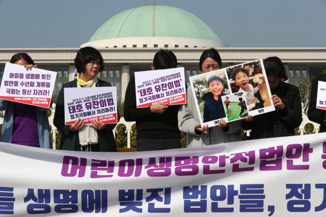 21일 오전 서울 여의도 국회의사당 정문 앞에서 정치하는엄마들 주최로 열린 기자회견에서 하준이와 태호, 윤호, 민식이 엄마 아빠 등 참가자들이 어린이 생명안전 관련 법안들을 정기국회에서 처리할 것을 촉구하고 있다. 연합뉴스