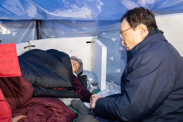 더불어민주당 이해찬 대표(오른쪽)가 25일 서울 종로구 청와대 분수대 앞에서 엿새째 단식 중인 자유한국당 황교안 대표를 만나 손을 맞잡고 있다. 연합뉴스