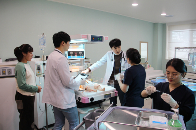 최근 대구과학대 NEST Center(간호전문교육센터)에서 진행된 IPE(전문직간 교육) 수업에서 대구과학대 간호학과 학생들(남색 실습복)과 아주대학교 의과대학 학생들(흰색 실습복)이 열성경련 환아 상황 실습을 하고 있다. 대구과학대 제공