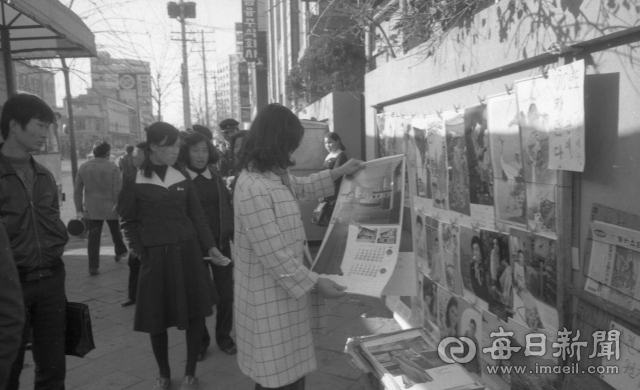 1975년 연말 대구시내 한 버스정류장 앞 가판에서 한 시민이 신년 달력을 펼쳐 보고 있다. 매일신문 DB