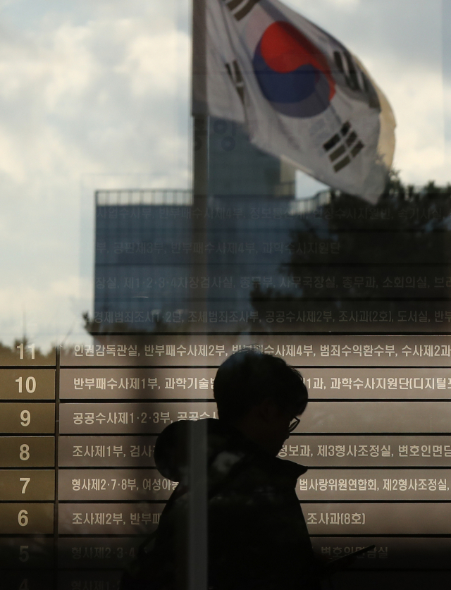 유재수 전 부산 경제부시장 영장이 발부된 다음 날인 28일 서울 서초구 서울중앙지검에 설치된 안내판 앞으로 검찰 관계자가 지나고 있다. 영장이 발부됨에 따라 금융위 재직 시절 금융업체들로부터 뇌물을 수수한 혐의를 받는 유 전 부시장에 대한 청와대 감찰 중단 경위와 관련해 당시 민정수석인 조국 전 장관을 비롯한 관계자들에 대한 검찰 수사가 속도를 낼 것이란 전망이 나오고 있다. 연합뉴스