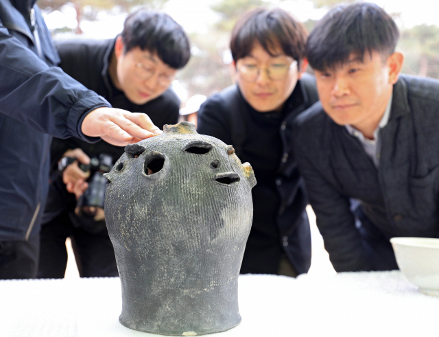 11일 오후 경북 와촌면 경산지식산업지구에서 출토된 유물 공개 및 현장설명회에서 화랑문화재연구원 관계자가 투각인면문옹형토기(透刻人面文甕形土器·사람 얼굴 모양 토기)를 경북대학교, 경산시, 언론 등 참석자들에게 공개하고 있다. 김영진 기자 kyjmaeil@imaeil.com