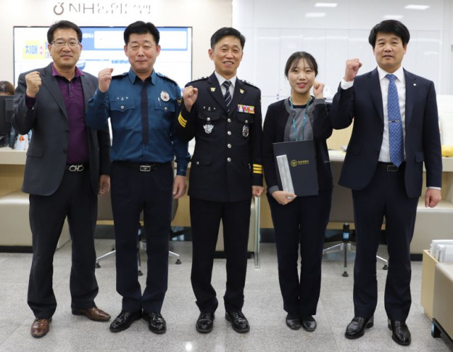 김준식 경북 의성경찰서장이 NH 농협은행 의성군지부를 찾아 보이스피싱을 예방한 직원에게 감사장을 전달하고, 기념 촬영을 하고 있다. 의성경찰서 제공