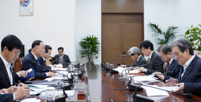 문재인 대통령이 13일 오전 청와대에서 홍남기 경제부총리겸 기획재정부 장관으로부터 2020년 경제정책방향에 대해 보고를 받고 있다. 연합뉴스