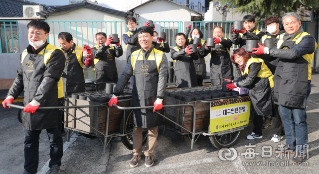 14일 대구 서구 비산동 대구연탄은행에서 ㈜대유기전공사 권오종(맨 오른쪽) 대표와 임직원들이 연탄배달 자원봉사에 앞서 파이팅을 외치고 있다. 성일권 기자 sungig@imaeil.com