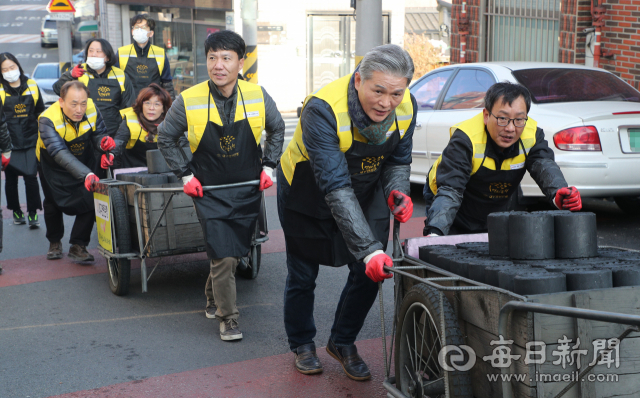 14일 대구 서구 비산동에서 ㈜대유기전공사 권오종(오른쪽에서 두 번째) 대표와 임직원들이 연탄배달 자원봉사를 하고 있다. 성일권 기자 sungig@imaeil.com