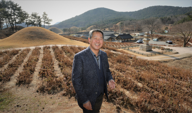 진병길 신라문화원장이 지난 9년 동안 문화재 주변 환경 개선사업을 벌였던 서악동 삼층석탑 일원을 배경으로 활짝 웃고 있다. 김도훈 기자