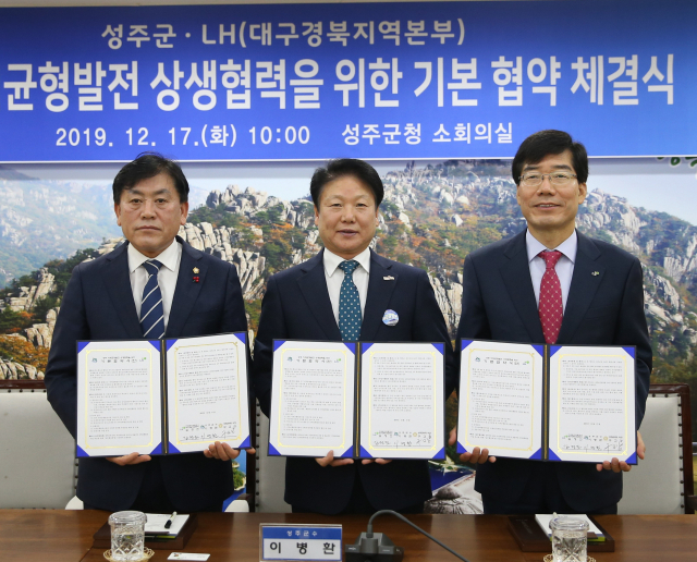 이병환(가운데) 성주군수와 김정진(오른쪽) LH대구경북지역본부장, 구교강 성주군의회 의장이 성주지역 균형발전 상생협력을 위한 기본협약을 체결한 뒤 협약서를 공개하고 있다. 성주군 제공