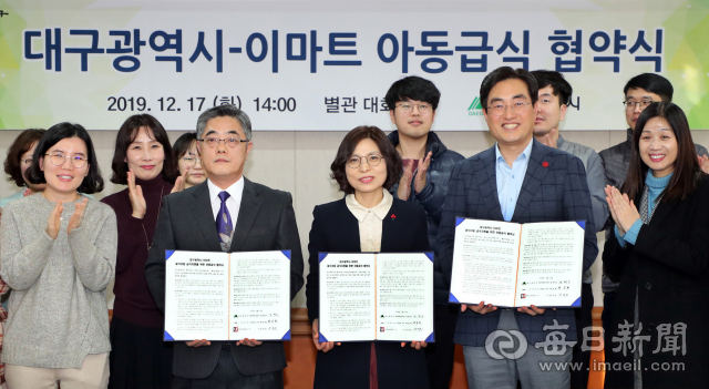 17일 오후 대구시청 별관에서 열린 대구시-이마트 아동급식 협약식에서 장석호(앞줄 왼쪽 두번째 부터) 유카드코리아(주) 이사, 강명숙 대구시 여성가족청소년국장, 박승학 이마트 CSR담당 상무 등이 협약서를 들어보이고 있다. 대구시청 제공