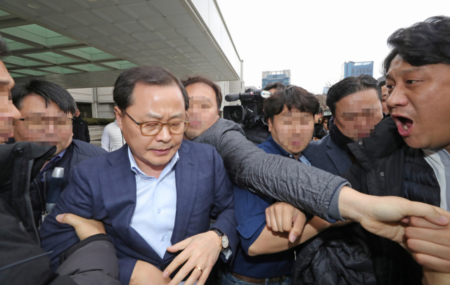 삼성전자서비스 노조와해 공작에 관여한 혐의를 받는 정금용 삼성물산 대표이사가 17일 오후 서울 서초구 서울중앙지법에서 열린 1심 선고 공판에서 징역 1년 6개월, 집행유예 3년을 선고받은 뒤 전국금속노조 삼성전자서비스지회 관계자 등의 항의를 받으며 법원을 빠져나오고 있다. 연합뉴스