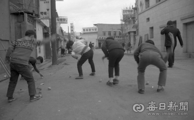1970년 대구의 한 동네 큰 길에서 아이들이 팽이를 치고 있다. 매일신문 DB.