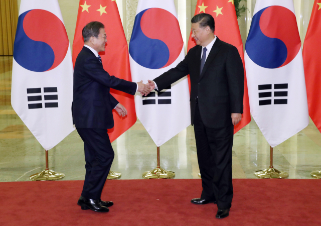 문재인 대통령과 시진핑 중국 국가주석이 23일 베이징 인민대회당에서 정상회담 전 악수하고 있다. 연합뉴스