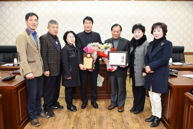 심칠(왼쪽에서 다섯번째) 군위군의회 의장과 박수현(왼쪽에서 네번째) 군위군의원이 동료 군의원들과 함께 수상을 축하하는 기념사진을 찍고 있다. 군위군의회 제공