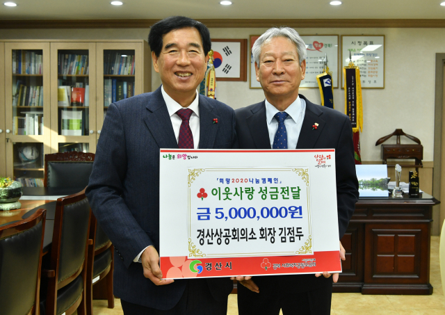 경산상공회의소 김점두 회장(오른쪽)이 24일 경산시청을 방문해 최영조 시장에게 지역의 저소득 가정을 위해 써달라며 성금 500만원을 기탁했다.