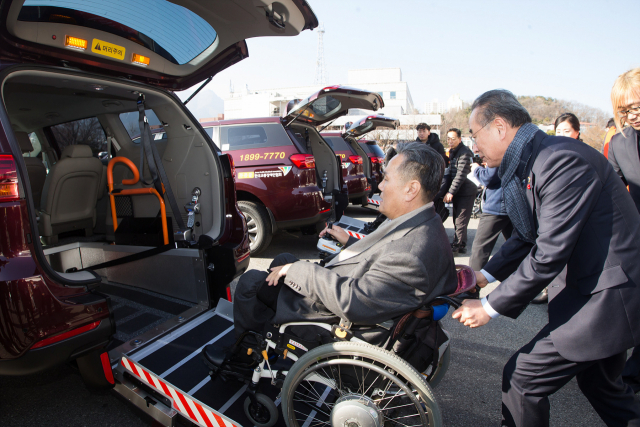 장세용(사진 오른쪽) 구미시장이 교통약자를 위한 차량 오랜지 캡(Orange Cab)에 장애인을 태우고 있다. 구미시 제공