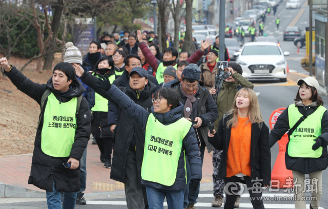 29일 영남대의료원 건물 옥상에서 고공농성 중인 해고노동자를 응원하기 위해 부산에서 대구까지 100km를 도보 행진한 민주노총 노조원들이 농성 중인 박문진 씨를 보며 손을 흔들고 있다. 성일권 기자 sungig@imaeil.com