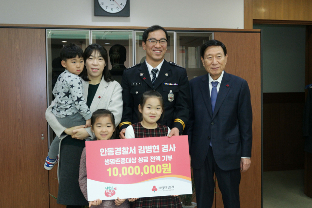 신현수(맨 오른쪽) 경북사회복지공동모금회 회장, 김병현 안동경찰서 옥동지구대 경사가 가족들과 함께 성금 전달식을 갖고 기념촬영을 하고 있다. 경북사회복지공동모금회 제공