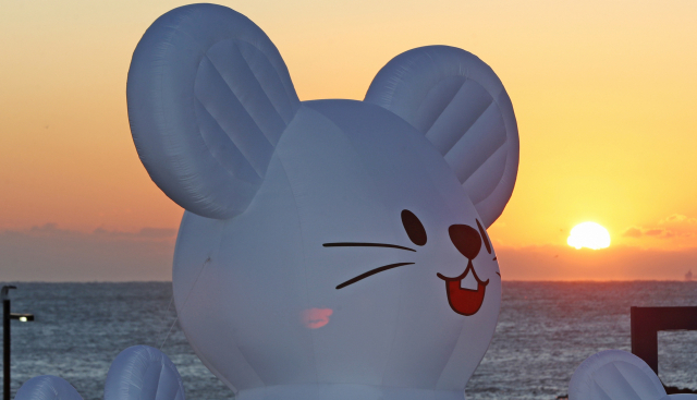 새해를 5일 앞둔 27일 오전 동해안 일출을 가장 먼저 볼 수 있는 울산시 울주군 서생면 간절곶에서 흰 쥐 조형물 너머로 해가 뜨고 있다. 2020년은 경자년(庚子年)으로 흰 쥐의 해다. 연합뉴스