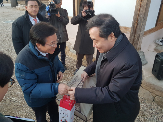 고윤환 문경시장이 31일 문경을 찾은 이낙연 총리에게 문경특산물인 오미자청과 사과를 선물하고 있다. 고도현 기자