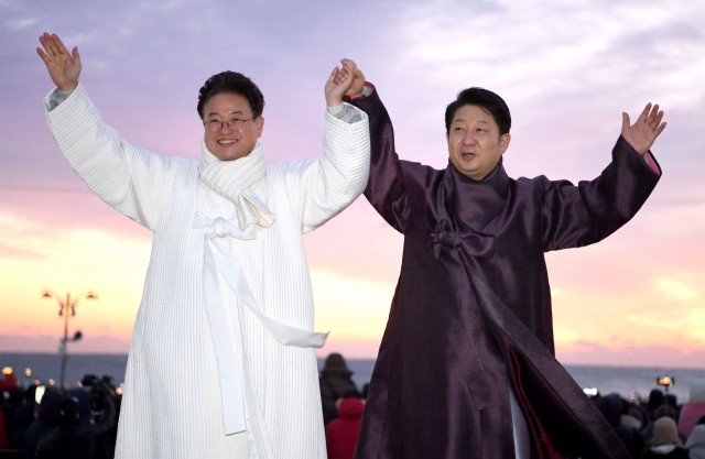 경북 포항 호미곶에서 2020년 새해 해맞이를 함께한 이철우 경북도지사와 권영진 대구시장이 손을 맞잡고 방문객들에게 인사하고 있다. 경북도 제공