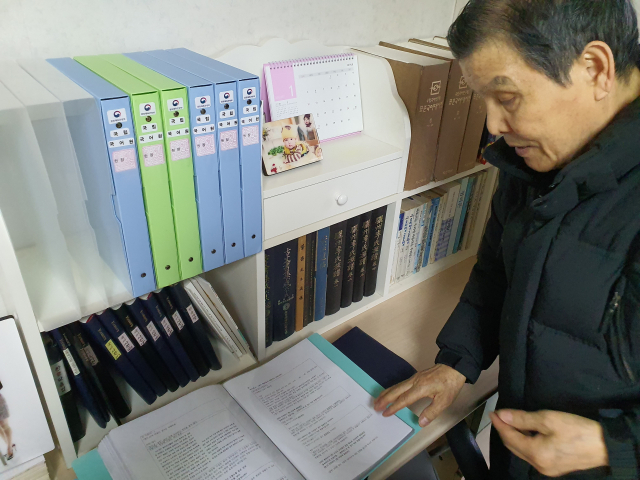 이동수 씨가 국립국어원에 보낸 질의서와 답변 자료집을 꺼내 설명하고 있다.김우정 기자