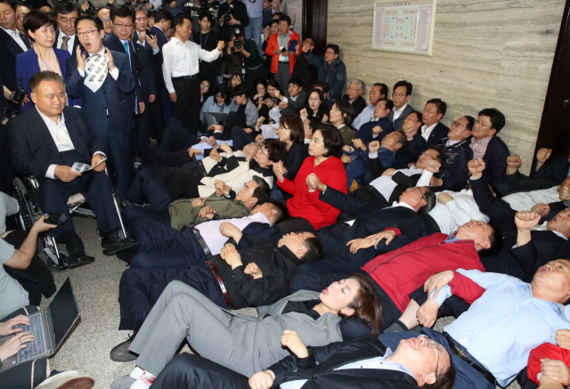 지난해 4월 26일 나경원 원내대표 등 자유한국당 의원들이 사법개혁특위가 열리는 국회 회의실 앞에 드러누워 이상민 위원장 등 참석자 진입을 막는 모습. 연합뉴스