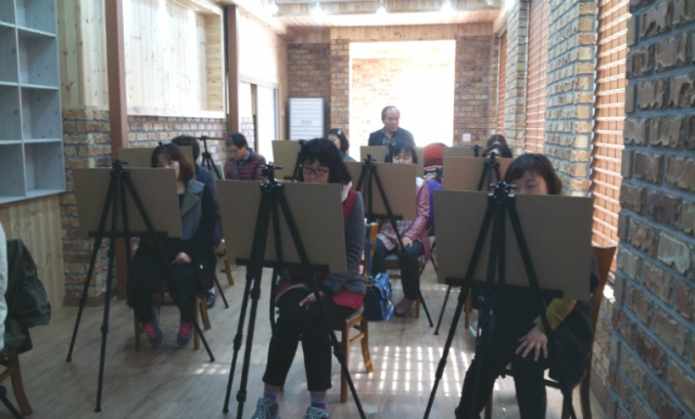 임천수 화백이 강사로 봉사하고 있는 상주지역의 한 미술교실 . 임 화백이 뒤에서 지켜보고 있다. 임천수 화백 제공