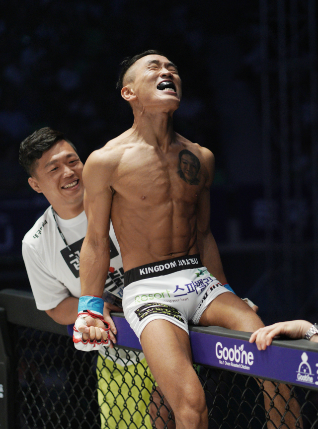 윤호영 소방관이 일본 선수를 제압한 뒤 케이지 위에 올라 승리를 만끽하며 소리를 지르고 있다. 로드 FC 제공