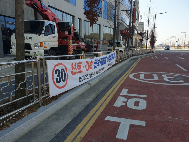 경북 예천군과 예천경찰서가 호명초등학교 후문 앞 네거리에 신호와 과속 단속장비를 설치하고 상반기 단속을 예고하는 현수막을 내걸었다. 윤영민 기자