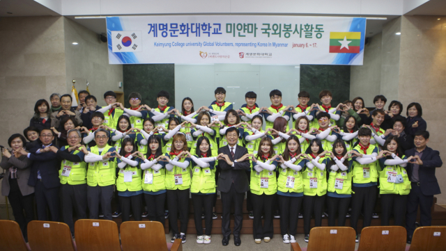 미얀마 국외봉사지로 출발 전 단원들과 박승호 총장을 비롯한 대학관계자들이 서로서로 하트를 그려보이고 있다. 계명문화대 제공
