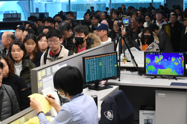 20일 오후 인천국제공항 제2터미널 입국장에서 질병관리본부 국립검역소 직원들이 동남아,우한발 비행기 입국자들을 발열 검사하고 있다. 질병관리본부는 19일 중국 우한에서 인천공항으로 입국한 중국 국적 여성이 우한 폐렴으로 불리는 신종 코로나바이러스에 감염됐다고 밝혔다. 연합뉴스