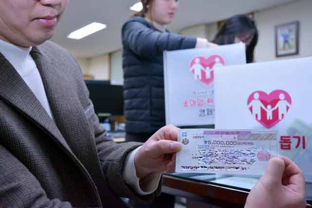 대구백화점 관계자가 익명의 기부자가 두고 간 500만원 수표를 들어 보이고 있다. 대구백화점 제공.