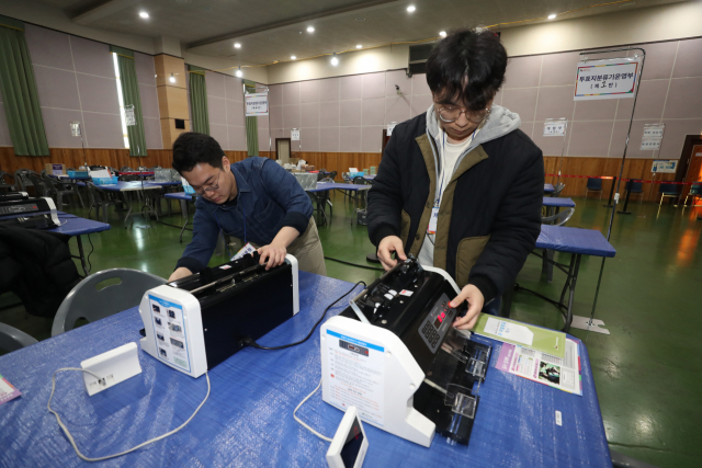 대구·경북 통합 신공항 건설 후보지 확정을 위한 주민 투표가 열린 21일 경북 의성군 청소년센터에 마련된 개표소에서 선거관리위원회 관계자들이 개표기 등을 살펴보고 있다. 공항 이전 후보지는 군위, 의성 2곳이다. 주민투표는 군위군민은 단독후보지와 공동후보지(군위 소보·의성 비안)에 대한 찬반을 묻는 투표용지 2장에, 의성군민은 공동후보지에 대한 찬반을 묻는 투표용지 1장에 기표하게 돼 있다. 연합뉴스