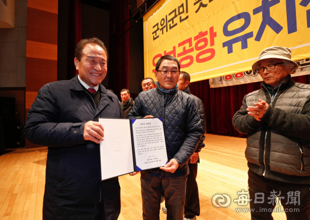 21일 밤 군위삼국유사문화회관에서 김영만(왼쪽) 군위군수가 박한배 통합신공항추진위원회 위원장으로부터 단독후보지인 우보공항 유치를 촉구하는 군위군민의 건의문을 전달받고 있다. 우태욱 기자 woo@imaeil.com