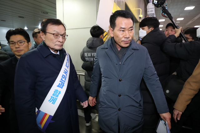 더불어민주당 이해찬 대표가 23일 오전 서울 용산역에서 귀성객들에게 설 인사를 한뒤 장애인 단체의 사과 요구를 받으며 승강장을 빠져나가고 있다. 연합뉴스