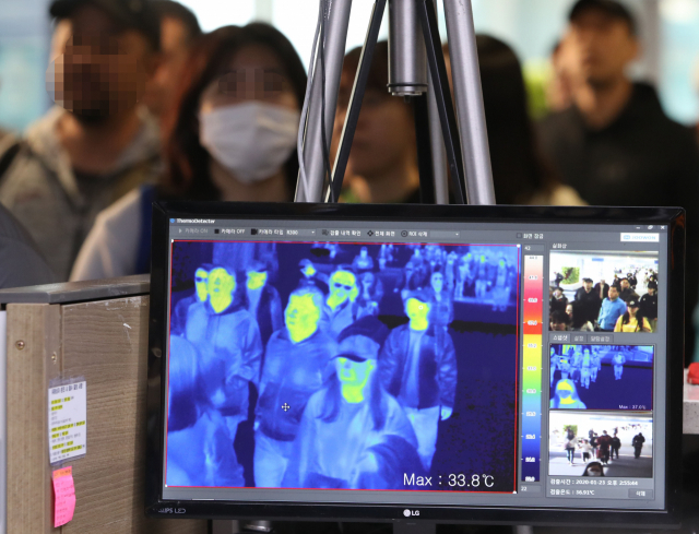 23일 오후 인천국제공항 1터미널 입국장에서 질병관리본부 국립검역소 직원들이 열화상 카메라로 승객들의 체온을 측정하고 있다. 연합뉴스