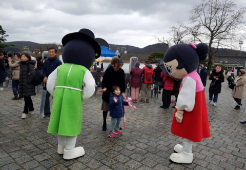 설 연휴 엄마와 함께 보문관광단지 호반광장을 찾은 어린이 관광객이 선비투어 캐릭터와 인사를 나누고 있다. 경북문화관광공사 제공