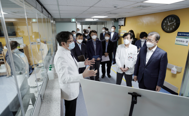 문재인 대통령이 28일 오전 신종 코로나바이러스 감염증 대응 의료기관인 서울 중구 국립중앙의료원에서 고임석 대응TF 팀장의 설명을 듣고 있다. 연합뉴스