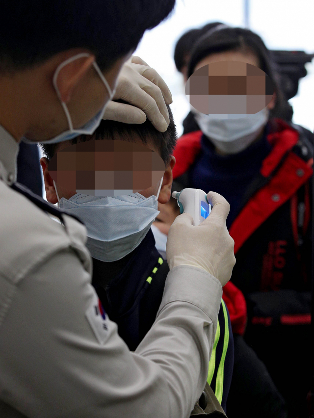 질병관리본부가 중국 전역 입국자를 대상으로 전수검사와 건강상태 질문서 제출을 의무화한 28일 오전 대구국제공항 국제선 입국장에서 검역관이 상하이발 비행기 탑승객 중 우한시 방문자에 대해 발열검사를 하고 있다. 김영진 기자 kyjmaeil@imaeil.com