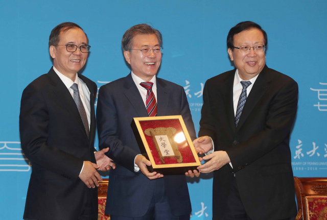 문재인 대통령이 2017년 12월 중국 베이징대학교를 방문, 연설에 앞서 베이징대 당서기 하오핑(오른쪽)으로부터 베이징대의 옛날 이름인 