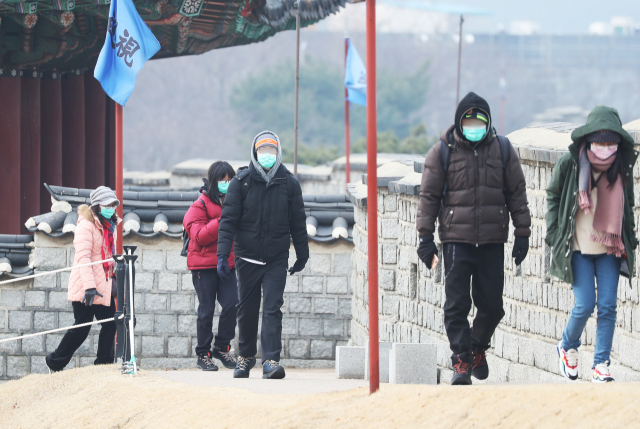 신종 코로나바이러스 감염증(신종코로나) 확산이 우려되고 있는 31일 오전 경기도 수원시 세계문화유산 화성(華城) 창룡문에서 마스크를 쓴 관광객들이 성곽길을 걷고 있다. 연합뉴스