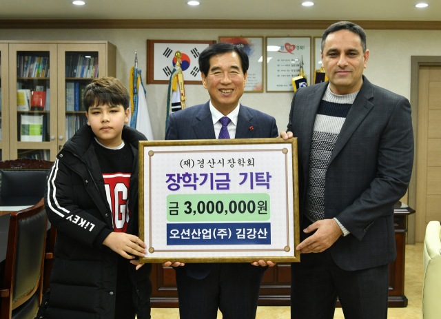 오션산업(주) 김강산 대표(맨 오른쪽)가 아들 김이브라힘과 함께 경산시장학회 최영조 이사장에게 장학기금 300만원을 기탁했다. 경산시 제공