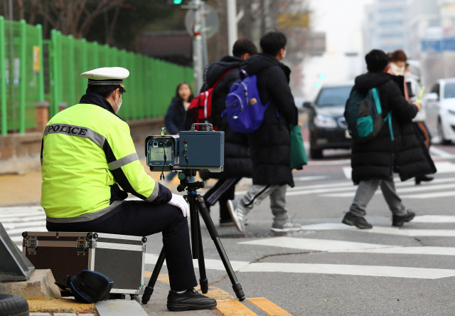 경찰이 한 초등학교 앞 어린이보호구역(스쿨존)에서 과속 차량을 단속하고 있다. 연합뉴스