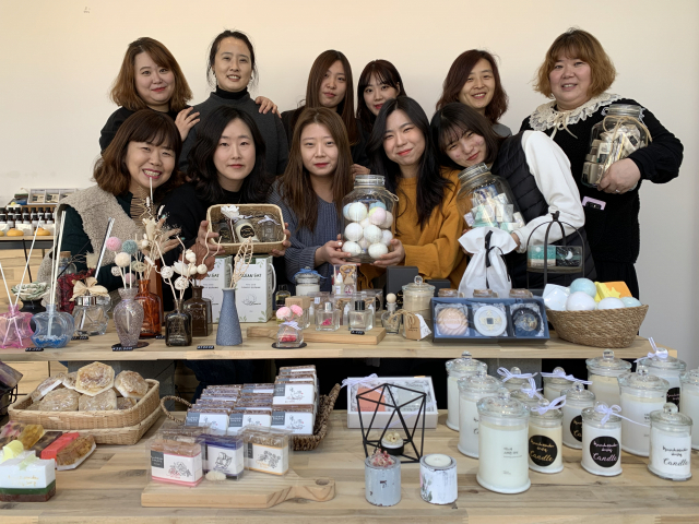㈜소폼 최숙진 대표(뒷줄 맨 왼쪽)와 이 회사 직원들이 자사 천연 비누, 입욕제, 향초, 향수 등 상품들을 선보이고 있다. 김윤기 기자