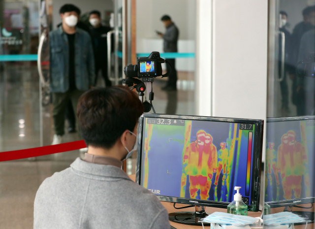 신종 코로나바이러스 감염증 확진 환자가 영화관 등 사람이 많이 모이는 공공장소를 출입한 사실이 알려진 31일 오후 대구시 달서구 웃는 얼굴 아트센터에서 센터 관계자들이 혹시 모를 사태에 대비해 열감지기를 설치하고 공연장을 출입하는 사람들의 체온을 살펴보고 있다. 연합뉴스