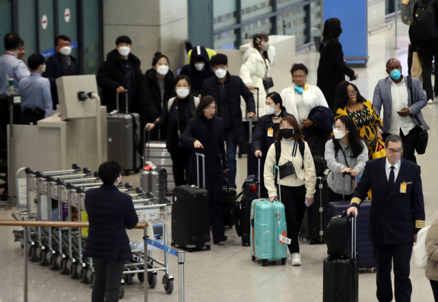 3일 오후 인천국제공항 1터미널에서 입국객들이 마스크를 쓰고 입국하고 있다. 연합뉴스