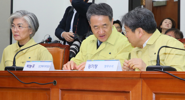 박능후 보건복지부 장관(가운데)과 강기정 청와대 정무수석이 5일 국회에서 열린 신종 코로나 바이러스 대응 제2차 고위당정협의회에서 논의하고 있다. 왼쪽은 강경화 외교장관. 연합뉴스