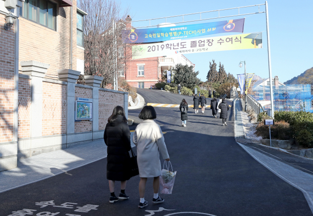신종코로나 바이러스 감염증 확산 우려가 커지는 가운데 5일 오전 서울 종로구 숙명여자중학교에서 열린 졸업식에서 3학년 학생들이 교문을 들어가고 있다. 이날 숙명여자중학교는 외부인이 졸업식에 오는 것을 최대한 자제해 달라고 공지하며 외부인의 본관 출입을 제한했다. 연합뉴스