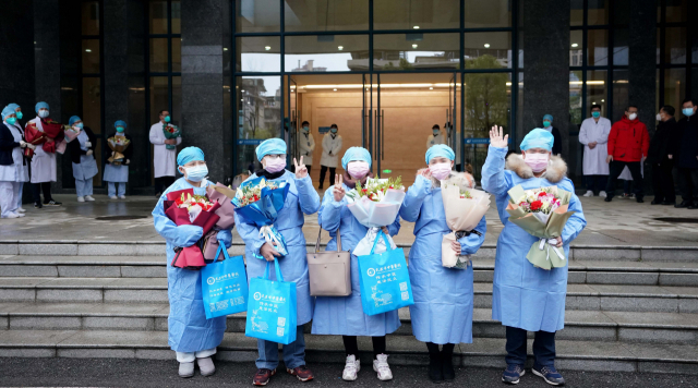 완치된 신종 코로나바이러스 감염증 환자들이 6일 중국 우한의 한 병원을 퇴원하고 있다. 이 병원에서 모두 23명의 환자가 한방과 양방 치료를 받고 완치돼 이날 퇴원했다. 연합뉴스